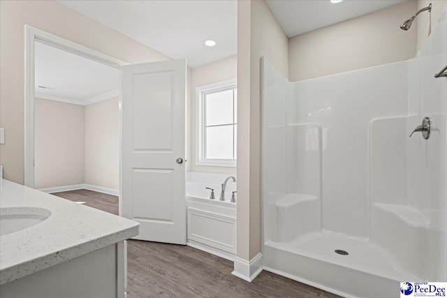 bathroom with a garden tub, a shower, wood finished floors, and vanity