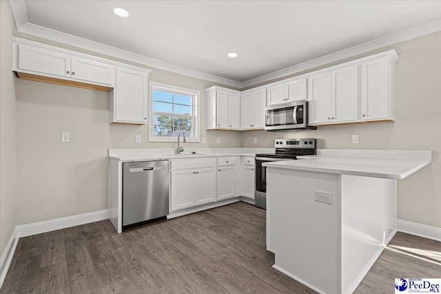 kitchen with stainless steel appliances, dark wood-style flooring, a sink, and white cabinetry