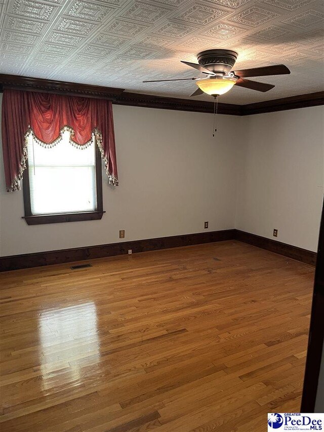 1840 New Zion Rd, Lake City, SC 29560 - empty room featuring a ceiling fan, wood finished floors, and an ornate ceiling