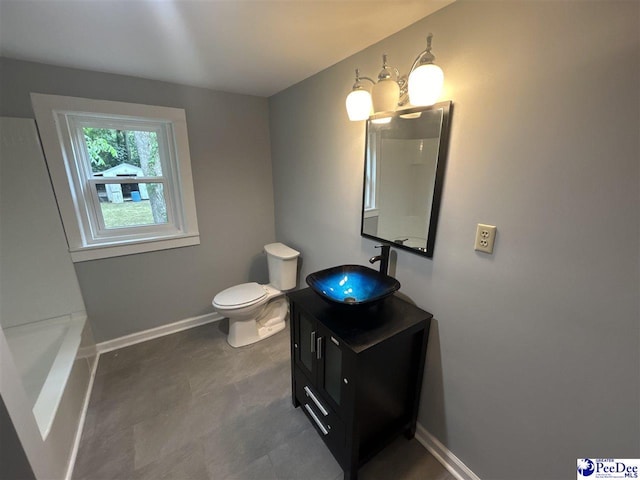 bathroom featuring vanity, toilet, and a bathing tub