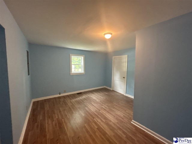 unfurnished room with hardwood / wood-style flooring