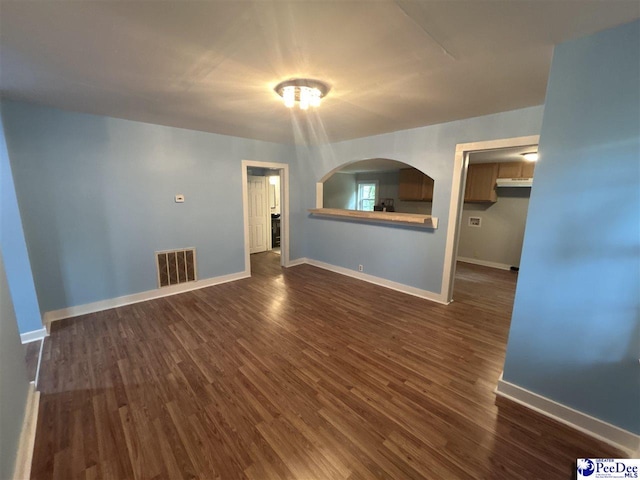 unfurnished living room with dark hardwood / wood-style flooring