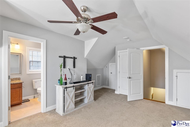 interior space with visible vents, a ceiling fan, vaulted ceiling, and light carpet