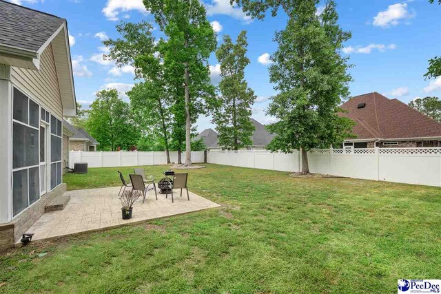 view of yard with central AC, a patio, and a fenced backyard