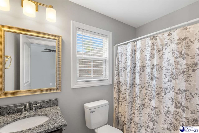 bathroom with toilet, vanity, and a shower with shower curtain