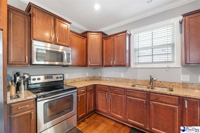 kitchen featuring dark wood-style floors, a sink, stainless steel appliances, crown molding, and light stone counters