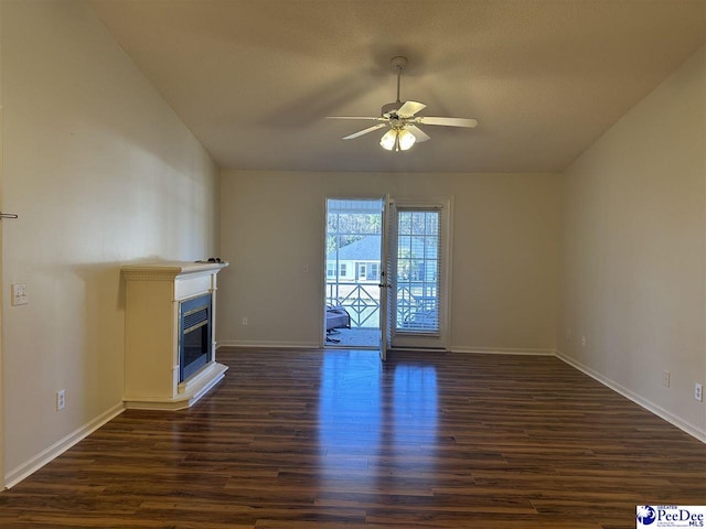 unfurnished living room with dark hardwood / wood-style flooring and ceiling fan