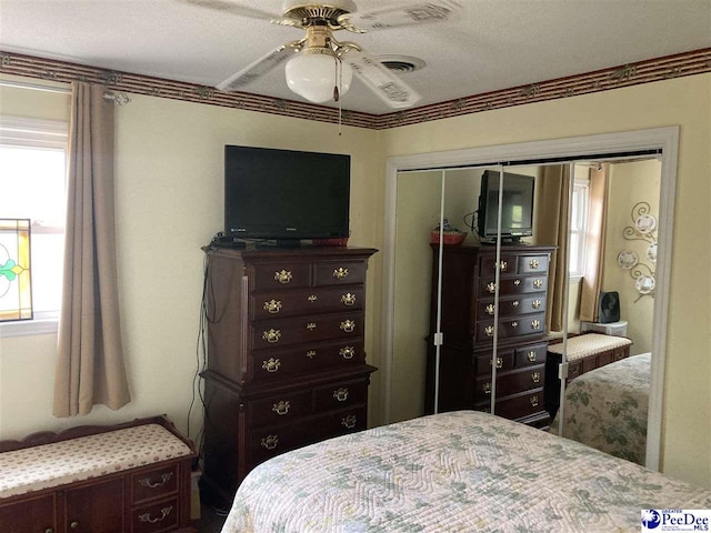 bedroom with ceiling fan, ornamental molding, and a closet