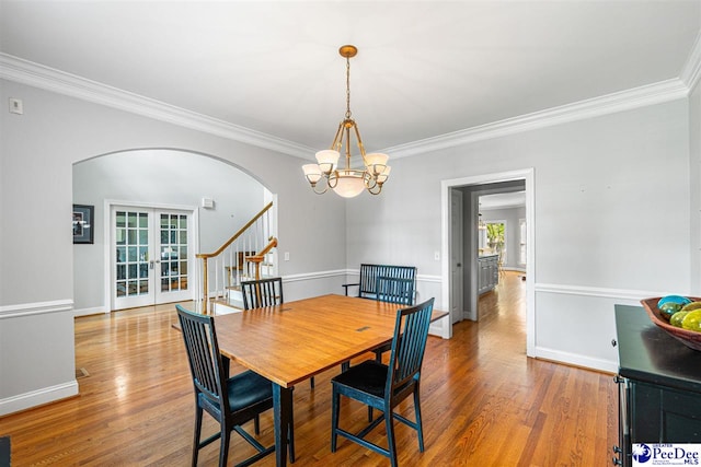 3326 Tennyson Dr, Florence, SC 29501 - dining space with arched walkways, a chandelier, crown molding, wood finished floors, and french doors