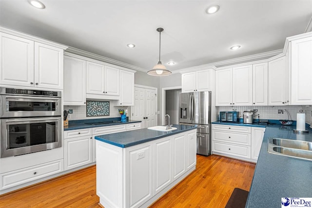 3326 Tennyson Dr, Florence, SC 29501 - kitchen featuring appliances with stainless steel finishes, white cabinetry, decorative backsplash, a center island with sink, and recessed lighting