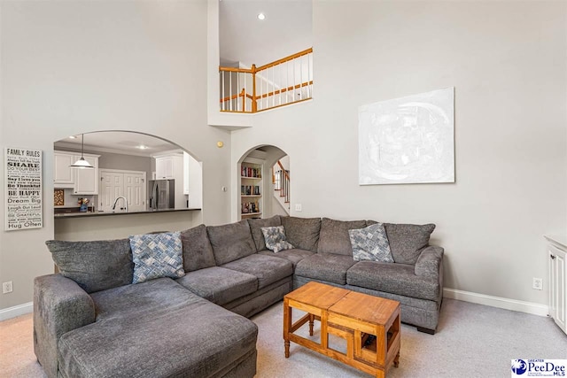 3326 Tennyson Dr, Florence, SC 29501 - living area featuring arched walkways, stairs, recessed lighting, a towering ceiling, and light carpet