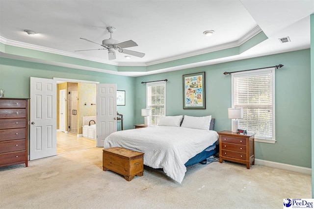 3326 Tennyson Dr, Florence, SC 29501 - carpeted bedroom with ornamental molding, a tray ceiling, multiple windows, ceiling fan, and ensuite bathroom