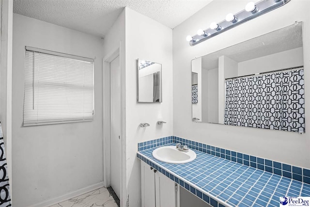 548 Mciver Rd, Florence, SC 29506 - bathroom featuring marble finish floor, baseboards, vanity, and a textured ceiling