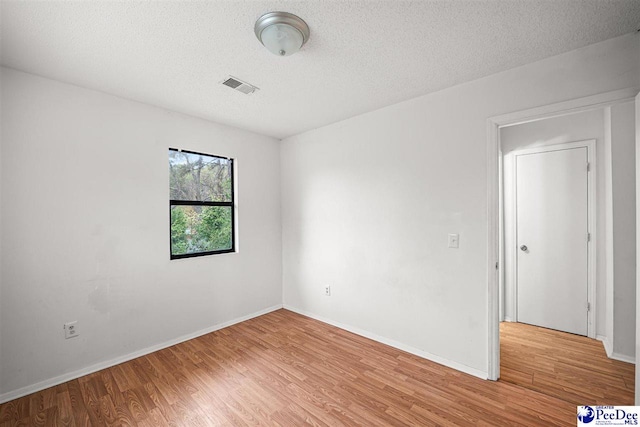 548 Mciver Rd, Florence, SC 29506 - empty room with baseboards, visible vents, light wood-style flooring, and a textured ceiling