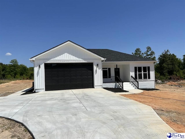 modern inspired farmhouse with a garage and covered porch