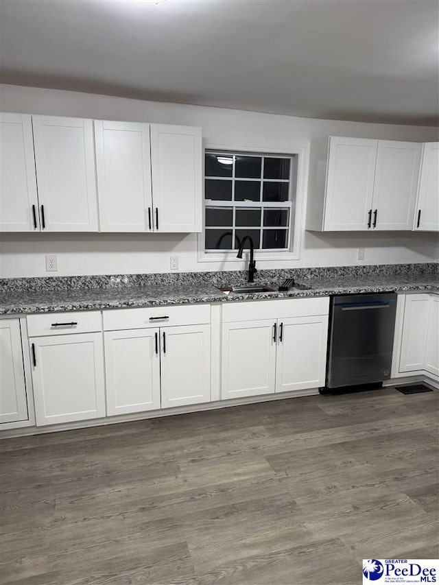 kitchen featuring white cabinetry, dishwasher, sink, dark stone countertops, and dark wood-type flooring