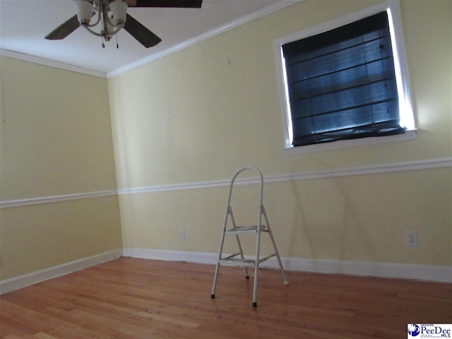 empty room with ornamental molding, hardwood / wood-style floors, and ceiling fan