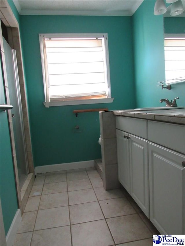 bathroom with ornamental molding, toilet, tile patterned flooring, and vanity