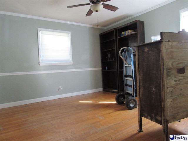 interior space with crown molding, a healthy amount of sunlight, and hardwood / wood-style floors