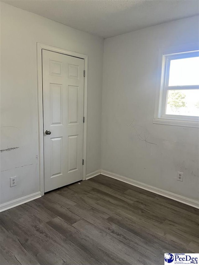 unfurnished room with dark hardwood / wood-style flooring