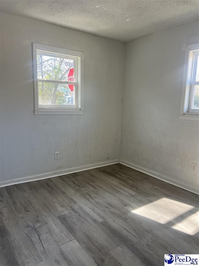 spare room featuring hardwood / wood-style floors and a textured ceiling