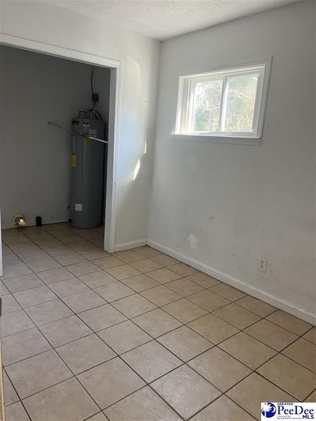 spare room featuring water heater and a textured ceiling