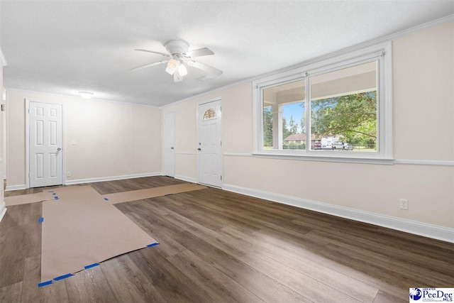 foyer entrance featuring wood finished floors, ceiling fan, baseboards, ornamental molding, and a textured ceiling