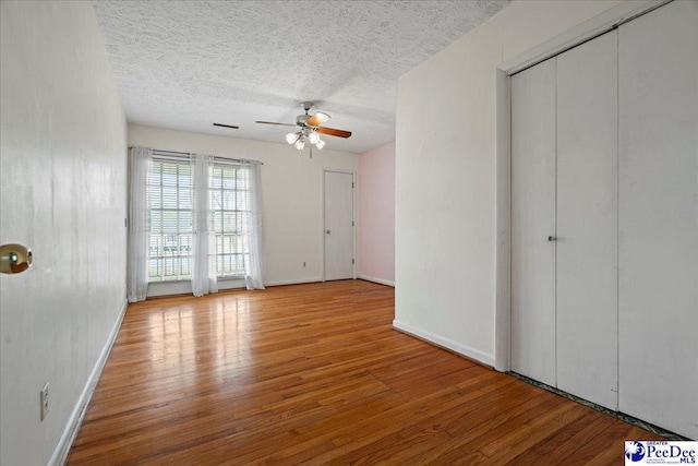 1101 E 3rd Ave, Lake View, SC 29563 - unfurnished bedroom featuring wood finished floors, a textured ceiling, baseboards, and a ceiling fan