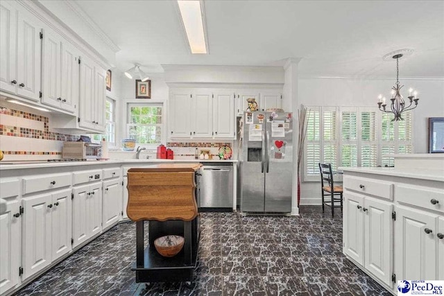 130 Nez Perce Dr, Darlington, SC 29532 - kitchen with appliances with stainless steel finishes, white cabinets, a chandelier, backsplash, and crown molding