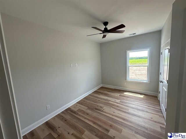 7845 E National Cemetery Rd, Florence, SC 29506 - unfurnished room featuring wood finished floors, a ceiling fan, and baseboards