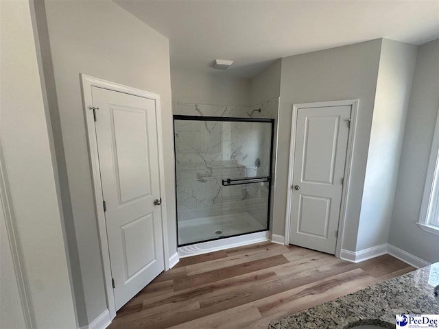 7845 E National Cemetery Rd, Florence, SC 29506 - bathroom with a marble finish shower, wood finished floors, and baseboards