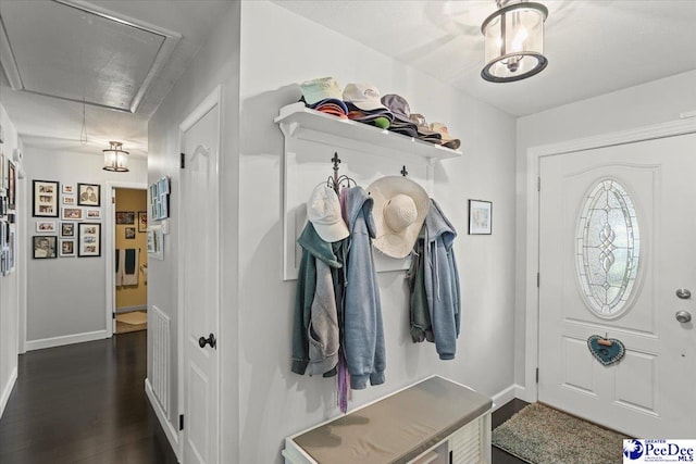 mudroom featuring attic access, baseboards, and dark wood-style floors