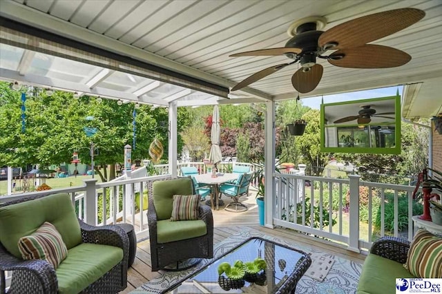 wooden deck featuring outdoor dining area and a ceiling fan