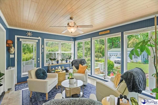 sunroom / solarium with a ceiling fan and an outdoor living space