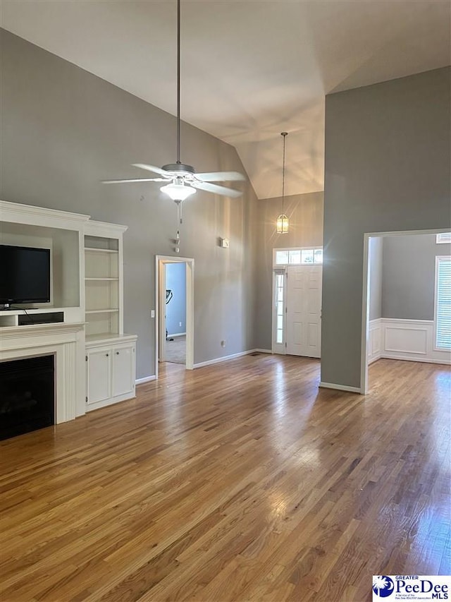 2143 Glenmore Way, Florence, SC 29505 - unfurnished living room with high vaulted ceiling, light wood-type flooring, ceiling fan, and a fireplace