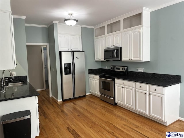 2143 Glenmore Way, Florence, SC 29505 - kitchen featuring appliances with stainless steel finishes, white cabinets, light wood-style flooring, ornamental molding, and dark stone countertops