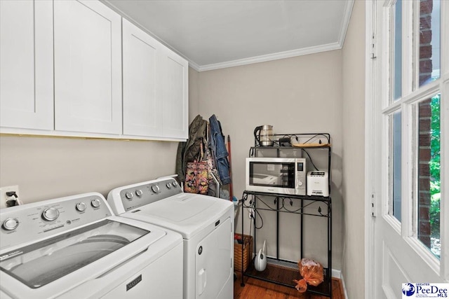 laundry room featuring cabinet space, independent washer and dryer, ornamental molding, and wood finished floors