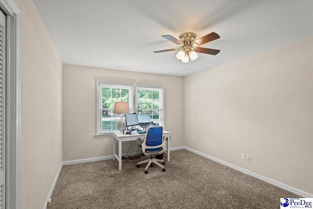 carpeted office space with ceiling fan and baseboards
