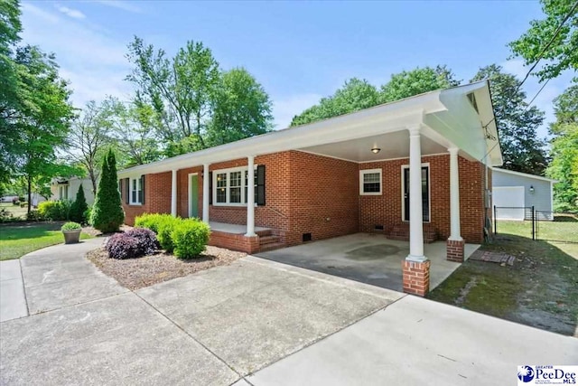 ranch-style house with fence, an attached carport, brick siding, crawl space, and concrete driveway