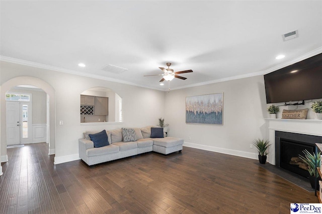 living room with crown molding, ceiling fan, and dark hardwood / wood-style flooring