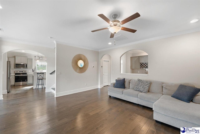 living room with ornamental molding, ceiling fan, and dark hardwood / wood-style flooring