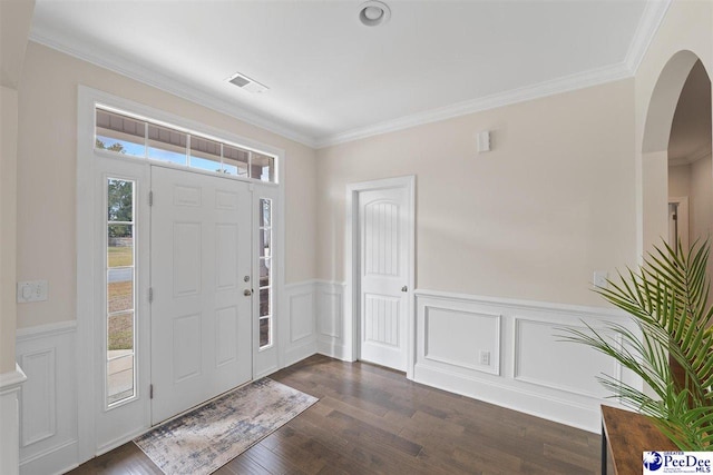 foyer featuring dark wood-style floors, wainscoting, visible vents, and crown molding