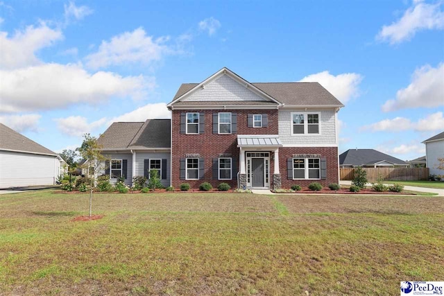 view of front of property featuring brick siding, fence, and a front lawn