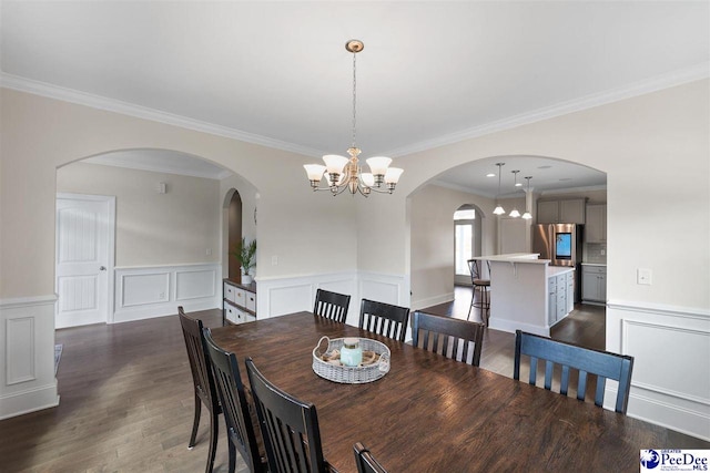 dining space with crown molding, dark hardwood / wood-style floors, and a notable chandelier