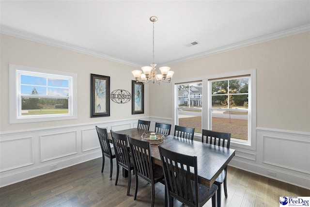 dining room featuring an inviting chandelier, crown molding, and dark wood-type flooring