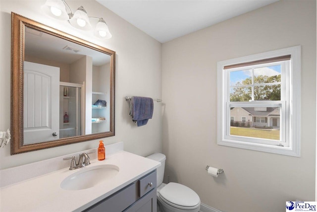 bathroom with vanity, a shower with shower door, and toilet