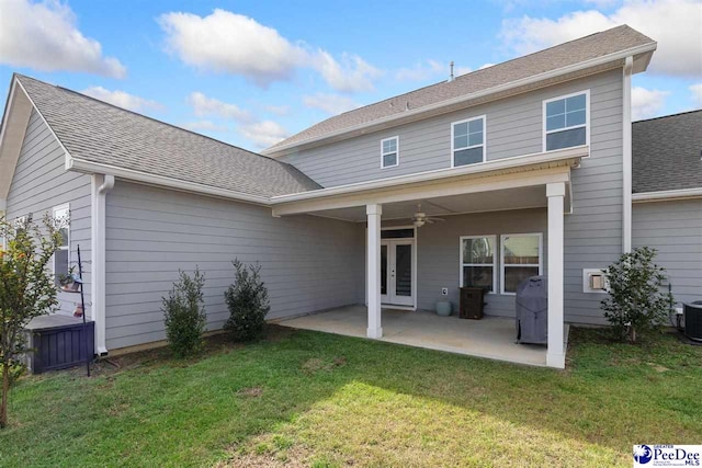 back of property featuring roof with shingles, a lawn, a patio area, and a ceiling fan