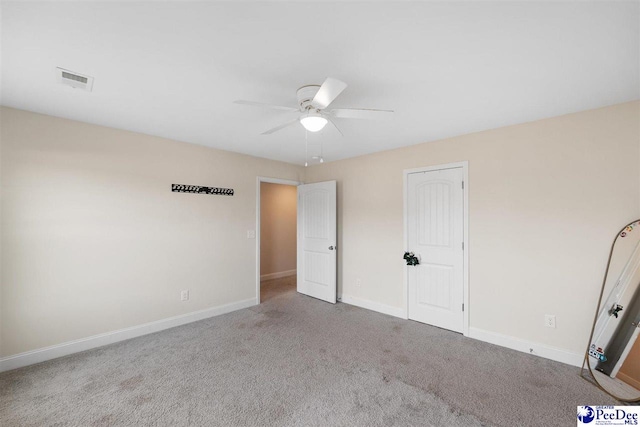 unfurnished bedroom featuring ceiling fan, carpet flooring, visible vents, and baseboards