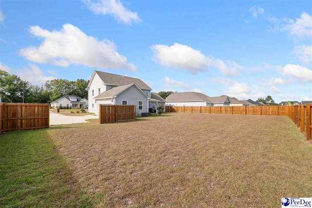 view of yard with a fenced backyard and a residential view