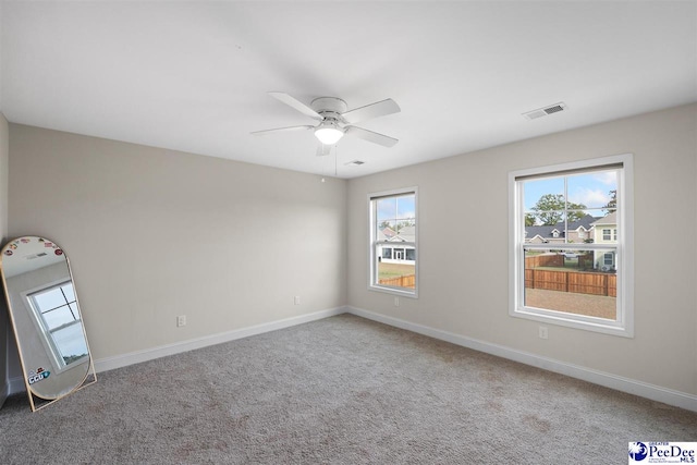 carpeted spare room with ceiling fan